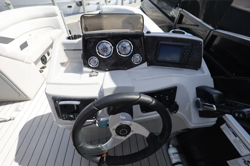 Slide: The Image of 2023 SunCatcher Select 320 RC boat dashboard with steering wheel and gauges. - 15