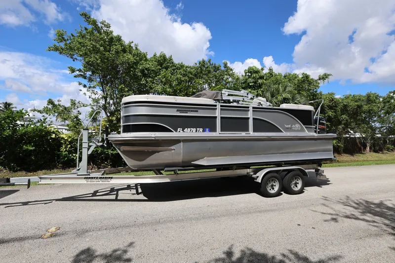 Slide: The Image of 2023 SunCatcher Select 320 RC pontoon boat on trailer, parked on a sunny day. - 2
