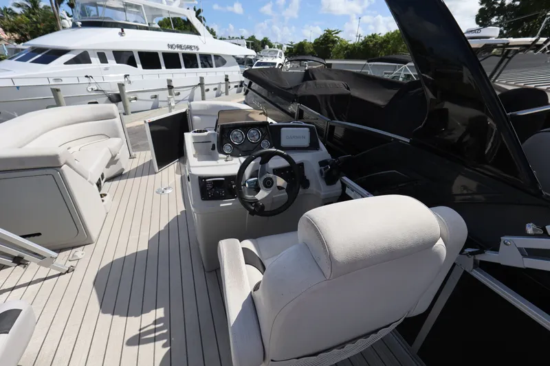 Slide: The Image of 2023 SunCatcher Select 320 RC boat interior with steering console and seating. - 18
