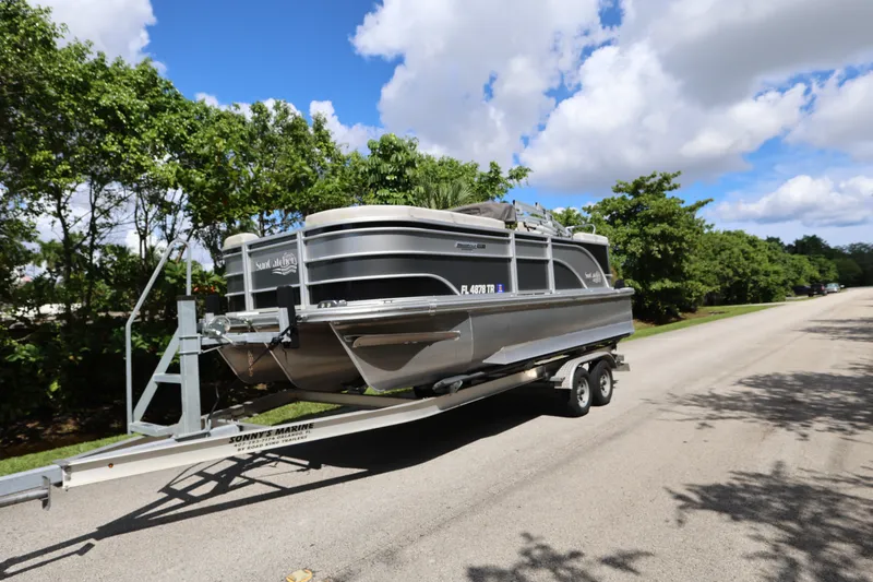 Slide: The Image of 2023 SunCatcher Select 320 RC pontoon boat on trailer, parked on a sunny road. - 1