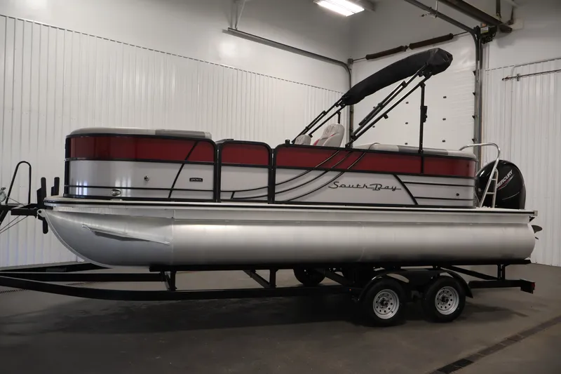 Slide: The Image of 2023 South Bay S222RS pontoon boat on trailer in indoor storage. - 8