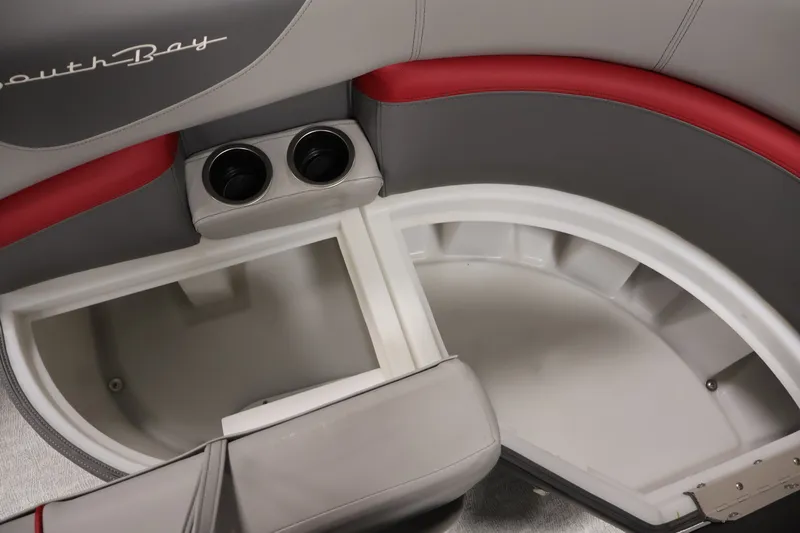 Slide: The Image of 2023 South Bay S222RS boat seat storage with cup holders, featuring gray and red upholstery. - 11