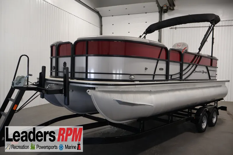 The Image of 2023 South Bay S222RS pontoon boat on trailer in indoor showroom. - 1