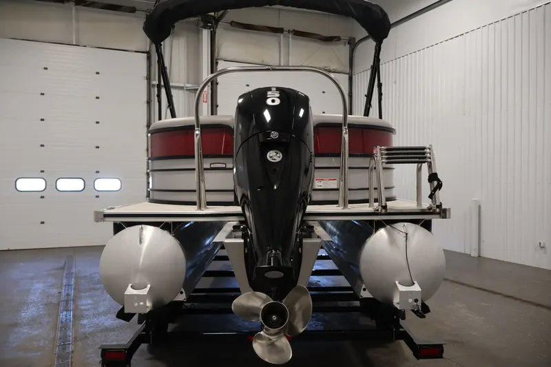 Slide: The Image of 2023 South Bay S222RS pontoon boat in a garage, rear view with motor and ladder. - 6
