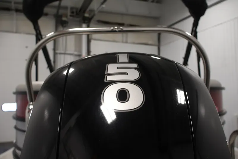 Slide: The Image of 2023 South Bay S222RS boat engine with "150" horsepower marking in a garage setting. - 35