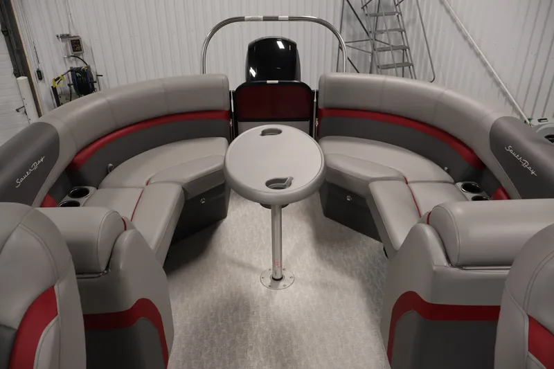 Slide: The Image of 2023 South Bay S222RS pontoon boat interior with gray and red seating and central table. - 28