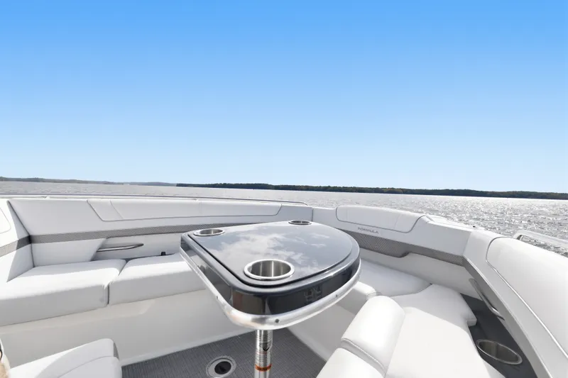 Slide: The Image of 2016 Formula 330 Crossover Bowrider interior with seating and table on open water. - 26