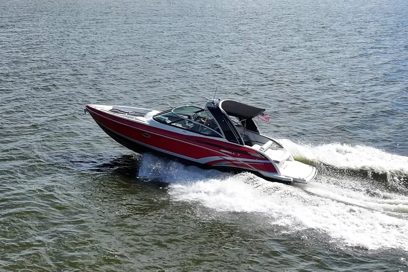 Slide: The Image of 2016 Formula 330 Crossover Bowrider cruising on open water, showcasing sleek design and performance. - 16