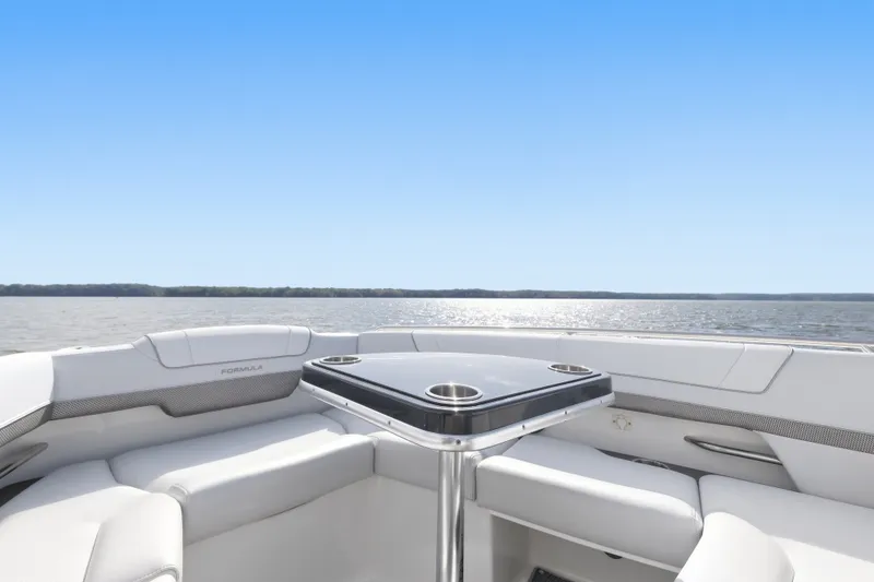 Slide: The Image of 2016 Formula 330 Crossover Bowrider interior with sleek seating and table on open water. - 24