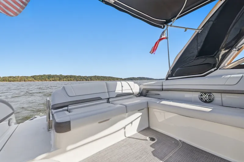Slide: The Image of 2016 Formula 330 Crossover Bowrider interior with seating, lake view, and American flag. - 30
