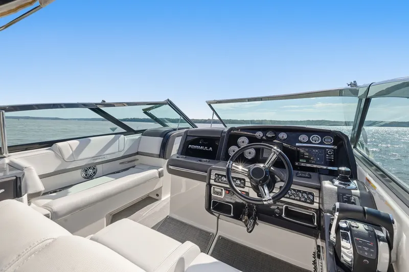 Slide: The Image of 2016 Formula 330 Crossover Bowrider cockpit with modern controls and panoramic water view. - 36
