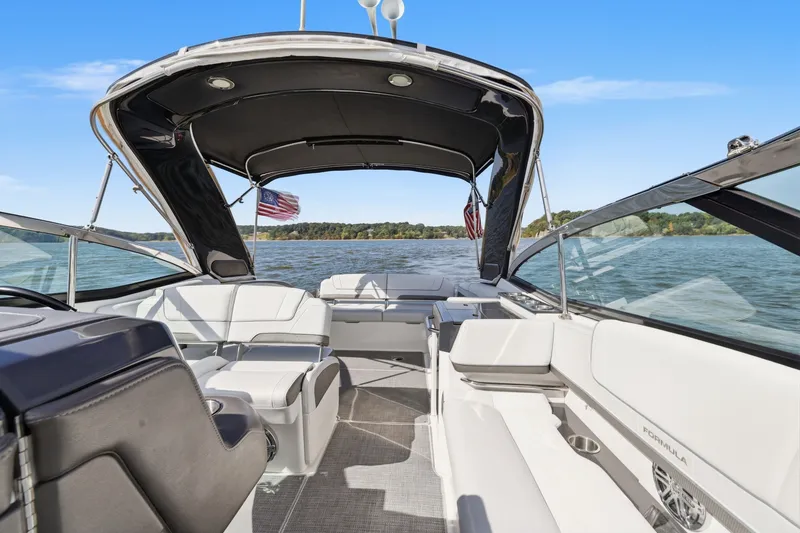 Slide: The Image of 2016 Formula 330 Crossover Bowrider on a lake, featuring spacious seating and canopy. - 41