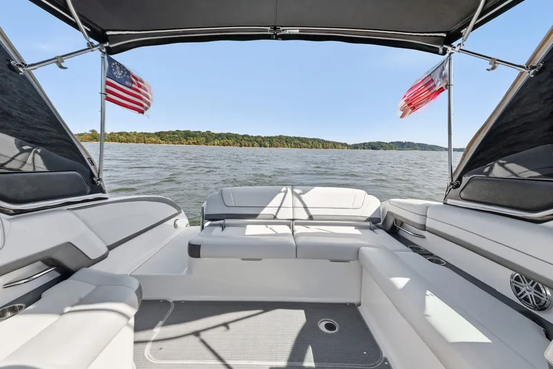 Slide: The Image of 2016 Formula 330 Crossover Bowrider on a lake, featuring spacious seating and American flags. - 29