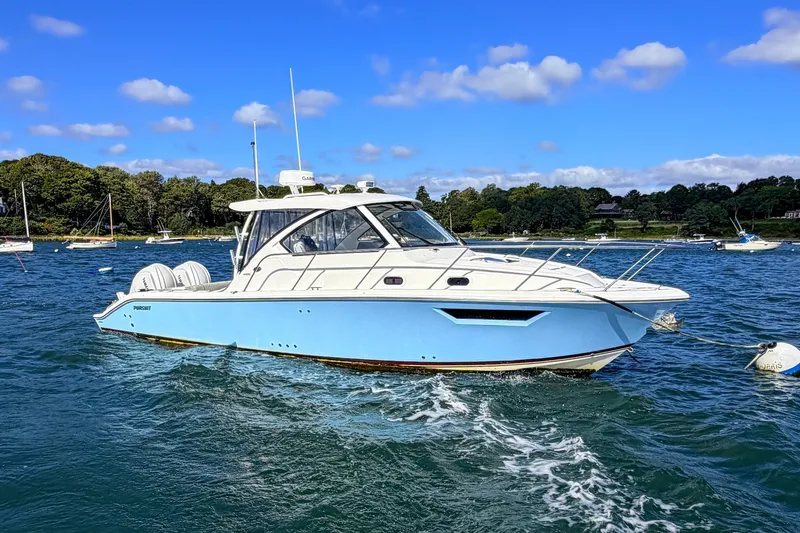 The Image of 2023 Pursuit OS 325 Offshore boat cruising on a sunny day with clear blue skies. - 1