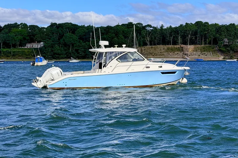 Slide: The Image of 2023 Pursuit OS 325 Offshore boat cruising on a scenic blue lake. - 3
