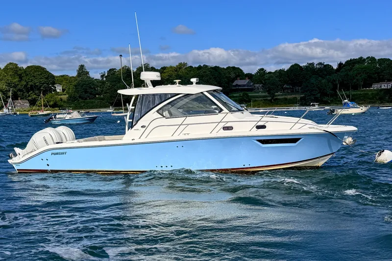 Slide: The Image of 2023 Pursuit OS 325 Offshore boat on water, clear sky, scenic background. - 2