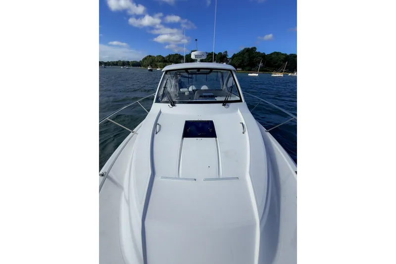 Slide: The Image of 2023 Pursuit OS 325 Offshore boat on calm water under blue sky. - 15