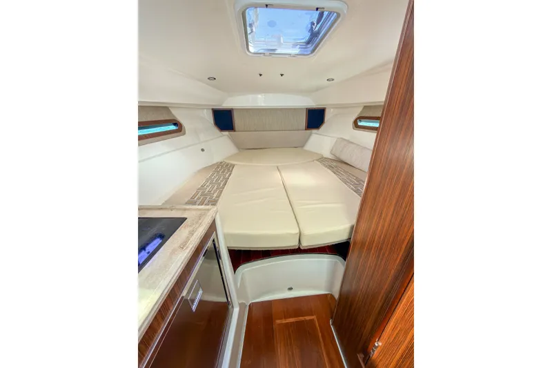 Slide: The Image of 2023 Pursuit OS 325 Offshore cabin interior with cozy bedding and modern amenities. - 11