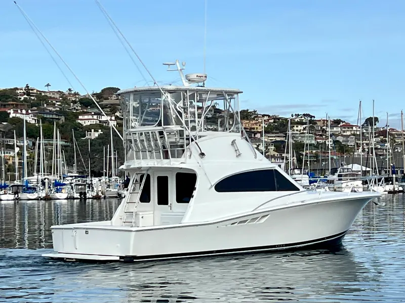 Slide: The Image of Luhrs 40 Convertible 2000 auf ruhigem Wasser vor einem Yachthafen. - 2