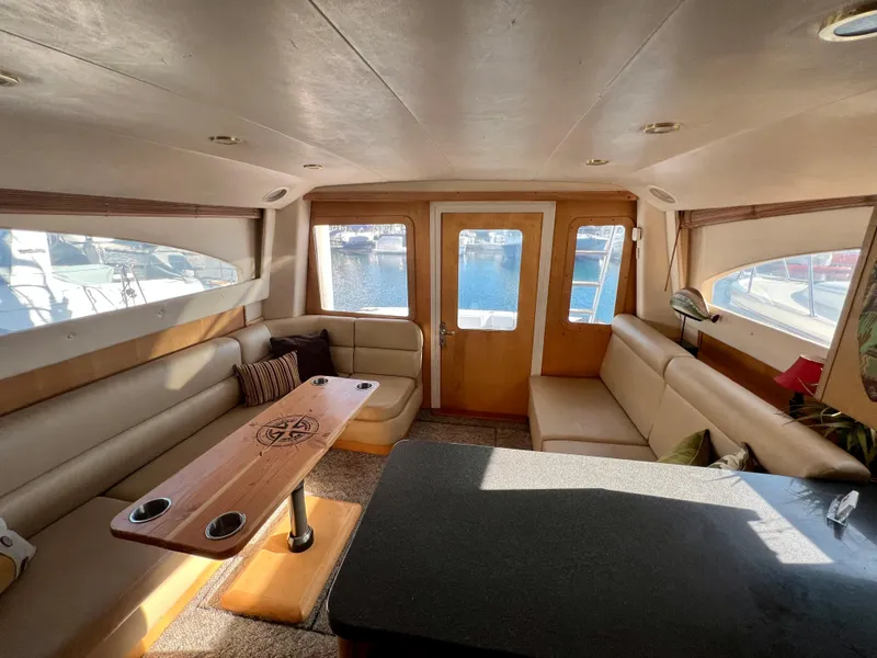 Slide: The Image of Innenraum der Luhrs 40 Convertible von 2000 mit beigen Sitzbänken und Holztisch. - 25