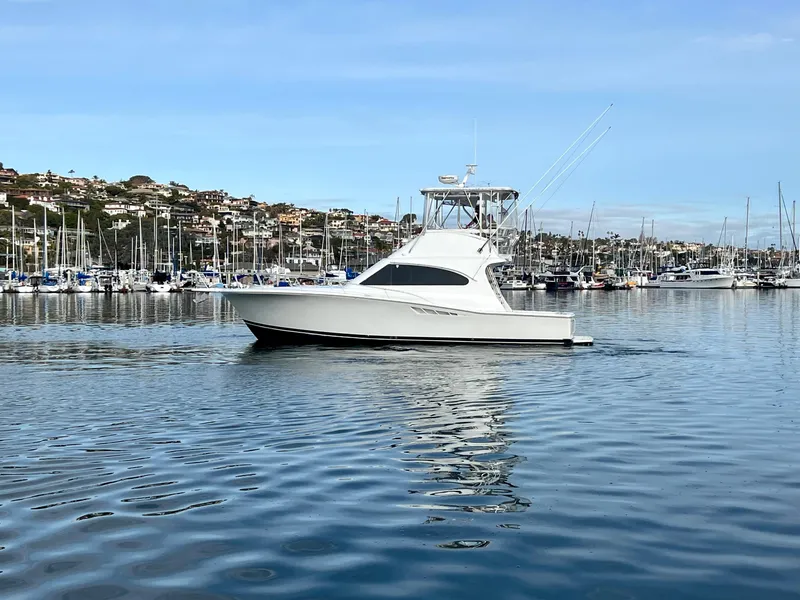 Slide: The Image of Ein Luhrs 40 Convertible aus dem Jahr 2000 fährt auf ruhigem Wasser, umgeben von einem Yachthafen. - 4