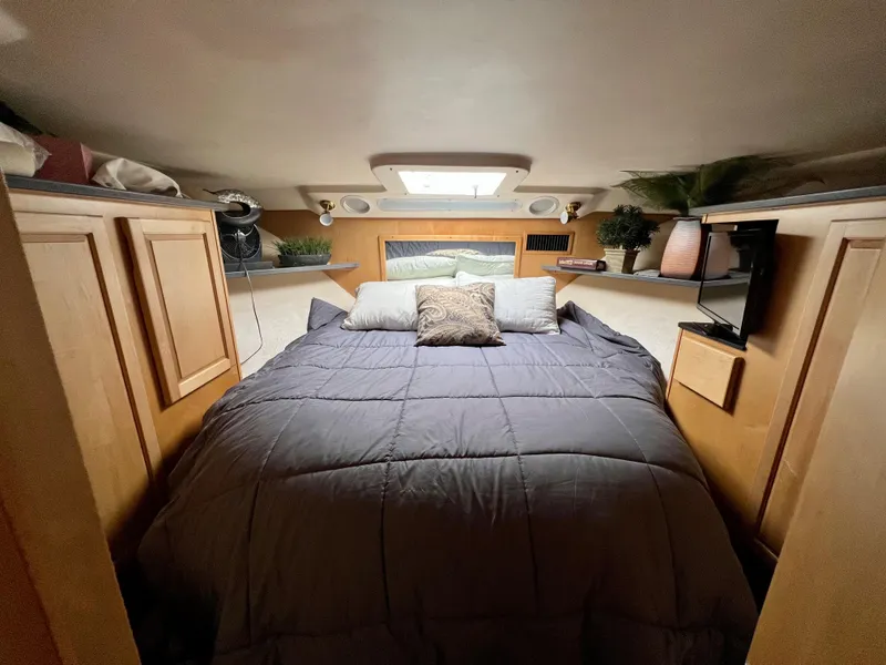 Slide: The Image of Das Bild zeigt eine gemütliche Kabine mit einem großen Bett, Holzmöbeln und einem kleinen Fernseher. - 23