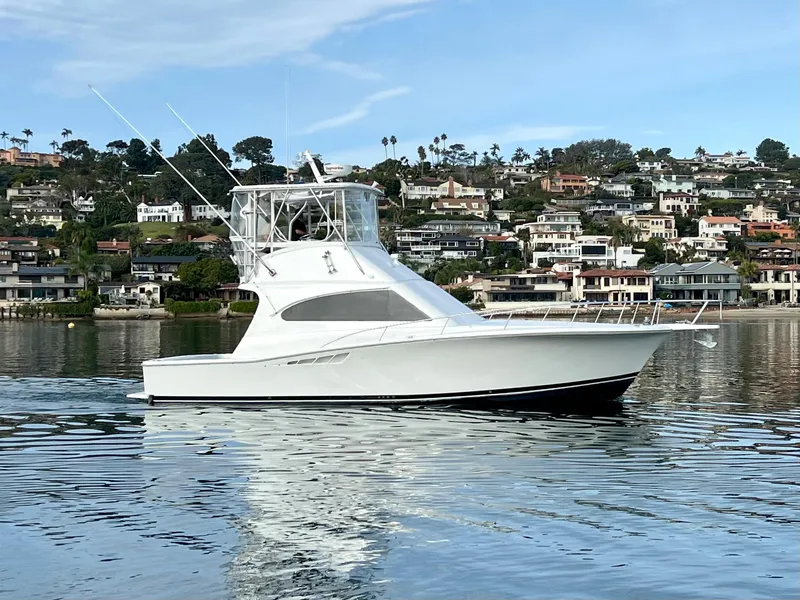 Slide: The Image of Ein Luhrs 40 Convertible von 2000 auf ruhigem Wasser vor einer Küstenstadt. - 1