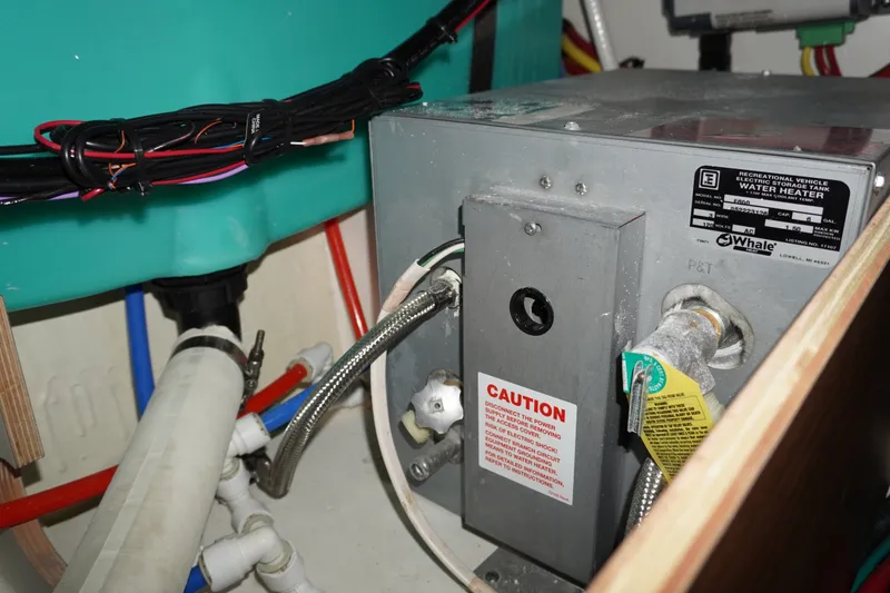 Slide: The Image of 2024 Jeanneau NC Sport 895 water heater system with caution label and wiring. - 31