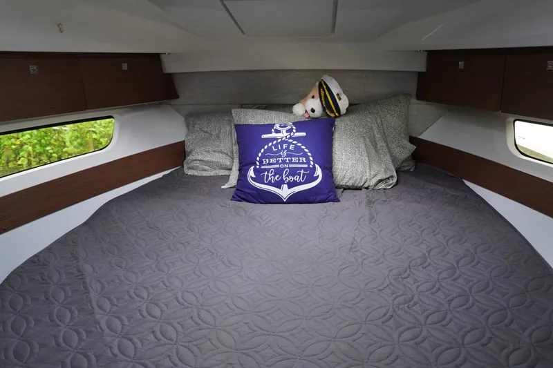 Slide: The Image of Cozy cabin interior of 2024 Jeanneau NC Sport 895 with decorative pillows and bedding. - 35