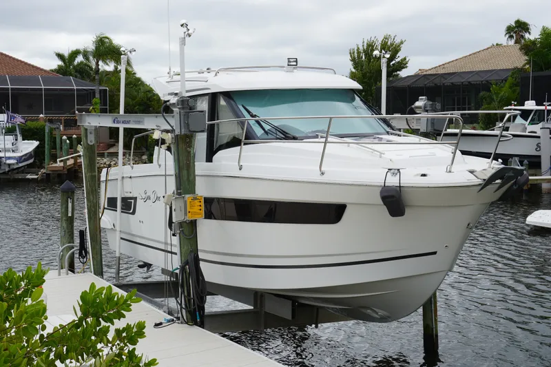 Slide: The Image of 2024 Jeanneau NC Sport 895 boat docked on a lift in a marina setting. - 12