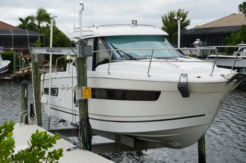 Slide: The Image of 2024 Jeanneau NC Sport 895 boat docked on a lift in a marina setting. - 11