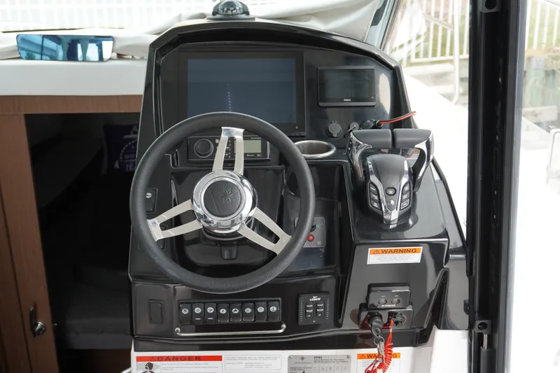 Slide: The Image of 2024 Jeanneau NC Sport 895 helm with steering wheel and control panel. - 17