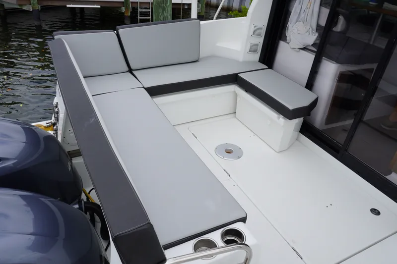 Slide: The Image of 2024 Jeanneau NC Sport 895 boat with cushioned seating area and dual engines. - 24