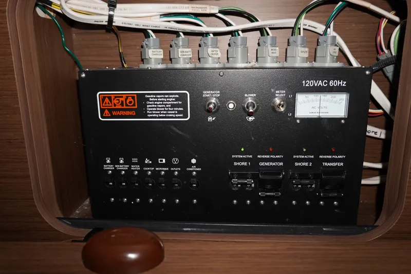 Slide: The Image of Electrical panel of 2024 Jeanneau NC Sport 895 boat, featuring various switches and warning labels. - 30
