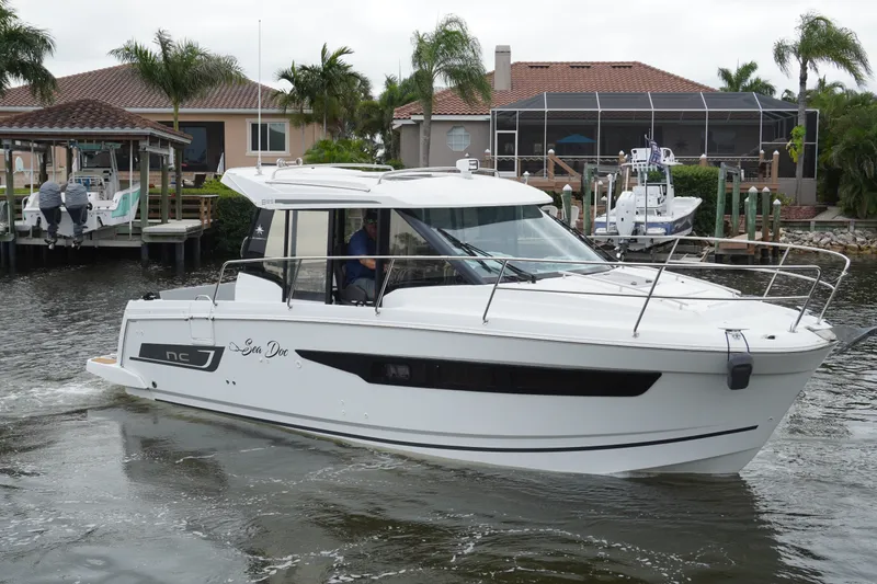 Slide: The Image of 2024 Jeanneau NC Sport 895 boat cruising near waterfront homes and docks. - 7