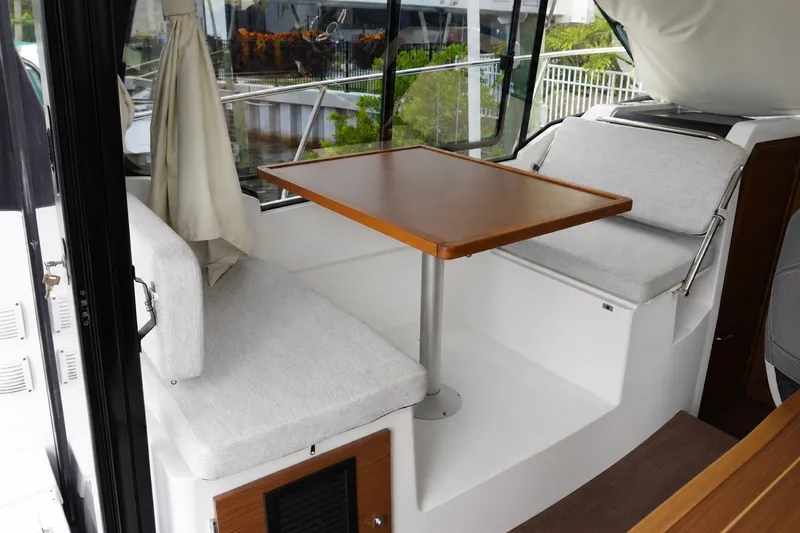 Slide: The Image of Interior seating area of 2024 Jeanneau NC Sport 895 with table and cushions. - 13