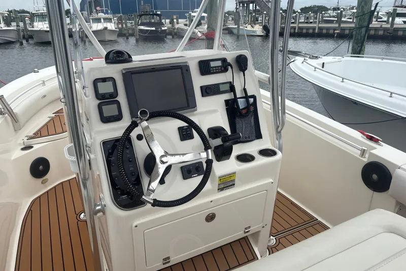 Slide: The Image of 2014 Cobia 237 Center Console boat dashboard with steering wheel and navigation equipment. - 4