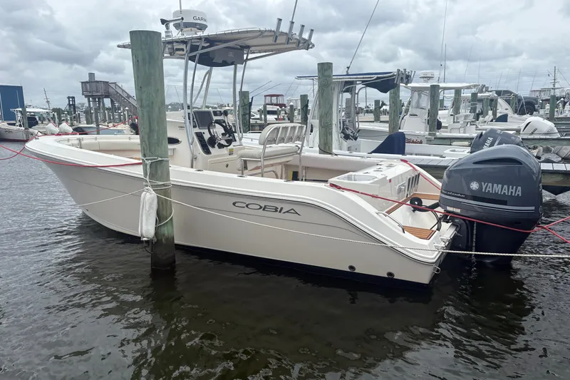 The Image of 2014 Cobia 237 Center Console boat docked with Yamaha outboard motor. - 0