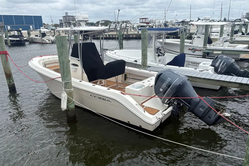 Slide: The Image of 2014 Cobia 237 Center Console boat docked with Yamaha outboard motor. - 12