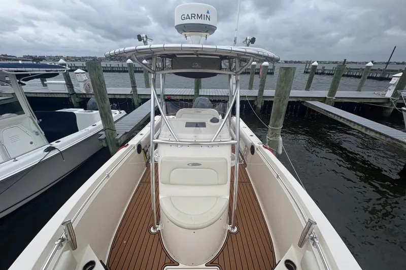 Slide: The Image of 2014 Cobia 237 Center Console boat docked, featuring Garmin equipment and sleek design. - 9