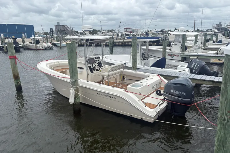 Slide: The Image of 2014 Cobia 237 Center Console boat docked with Yamaha outboard motor. - 1