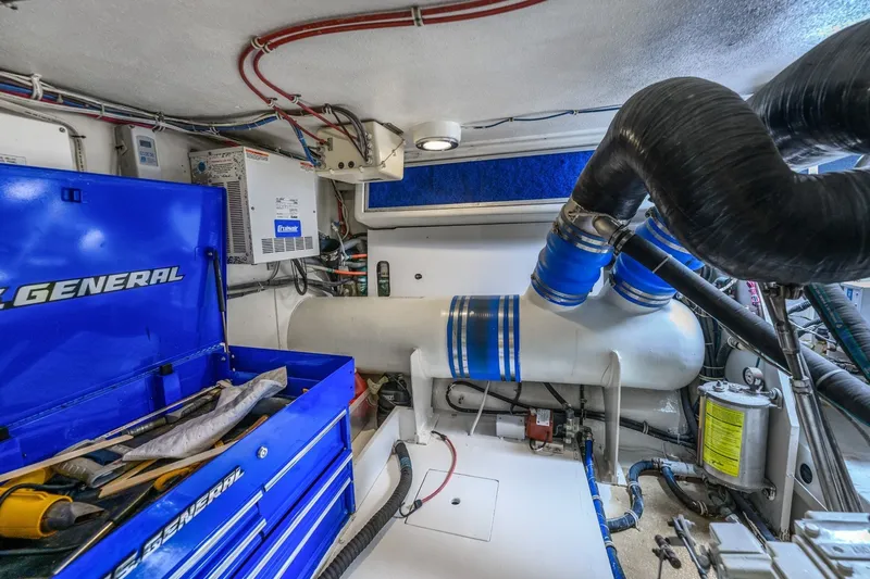 Slide: The Image of Engine room of 2000 Hatteras 55 Convertible yacht with blue tool chest and equipment. - 43