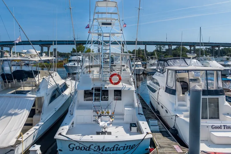 Slide: The Image of Docked 2000 Hatteras 55 Convertible yacht with marina and bridge in background. - 13