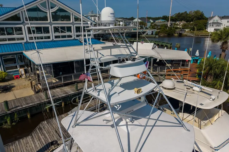 Slide: The Image of 2000 Hatteras 55 Convertible yacht docked near waterfront buildings and palm trees. - 6
