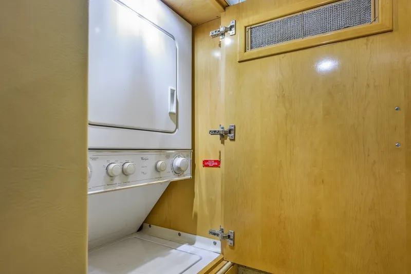 Slide: The Image of Laundry area with stacked washer and dryer in 2000 Hatteras 55 Convertible yacht. - 35
