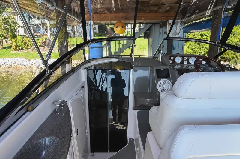 Slide: The Image of Interior view of a 2007 Regal Commodore 2665 boat with white seating and control panel. - 14