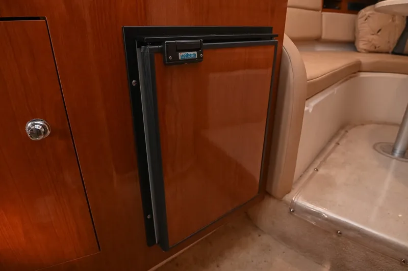 Slide: The Image of 2007 Regal Commodore 2665 interior with wooden cabinetry and compact fridge. - 28