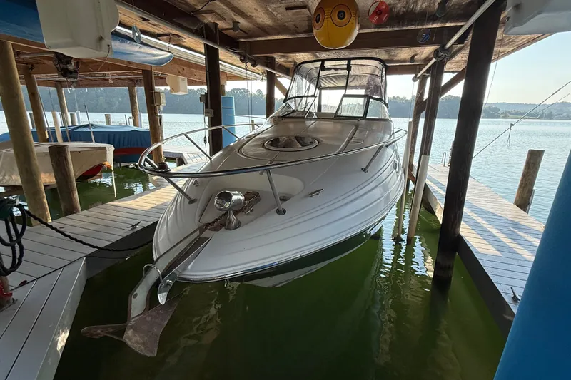 Slide: The Image of 2007 Regal Commodore 2665 boat docked in a covered marina, surrounded by calm water. - 7