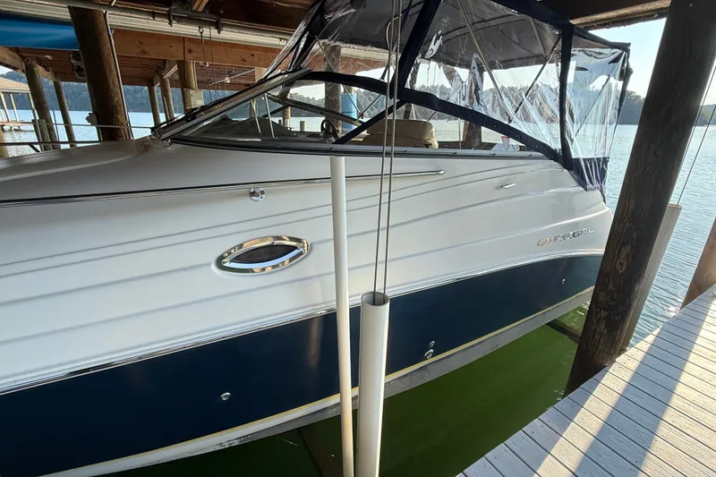 Slide: The Image of 2007 Regal Commodore 2665 boat docked under a wooden shelter by the water. - 3