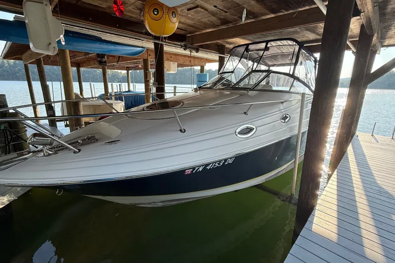 Slide: The Image of 2007 Regal Commodore 2665 boat docked under a wooden shelter by the lake. - 1